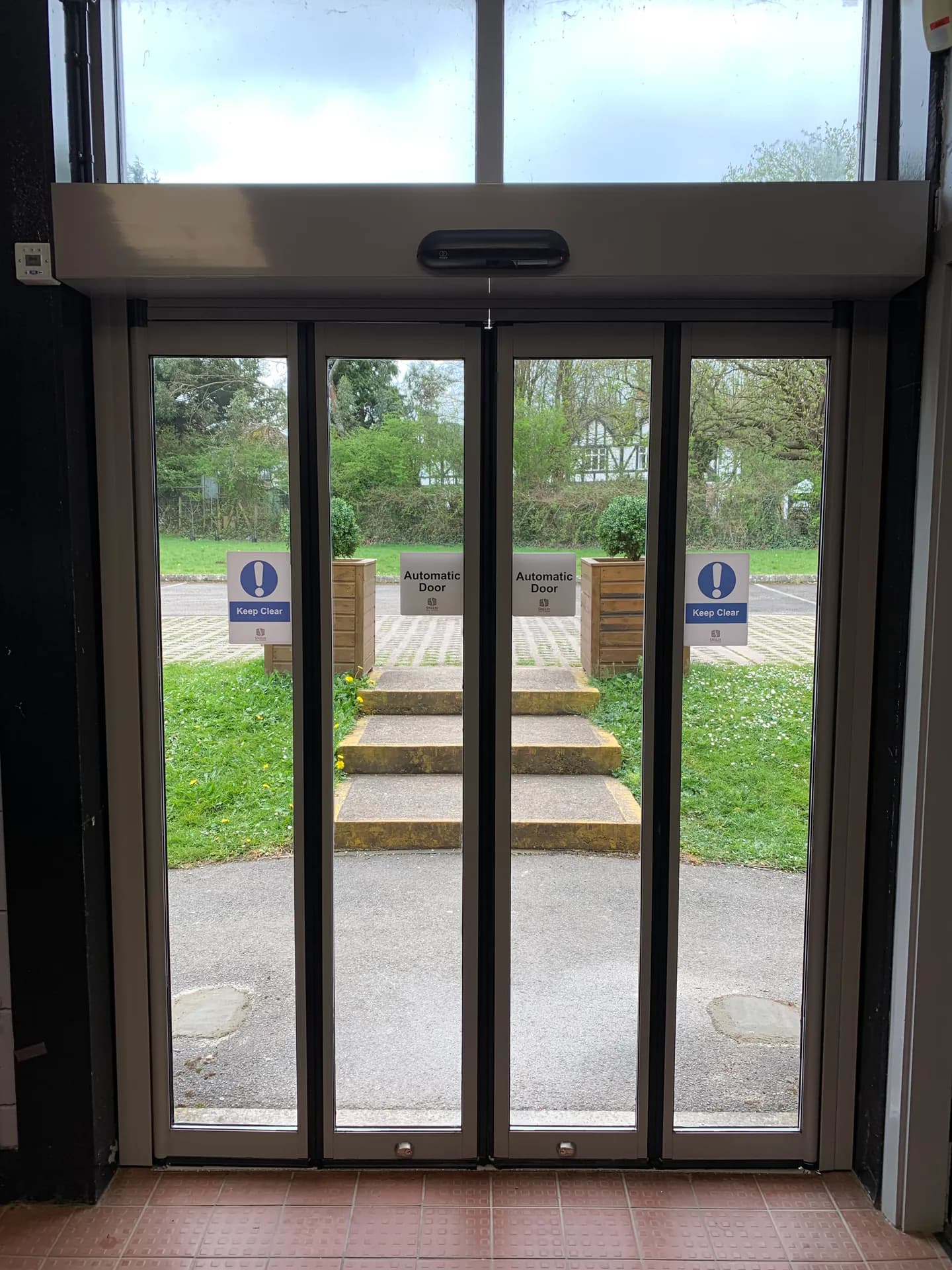 Automatic sliding doors in a dark glazed entrance screen
